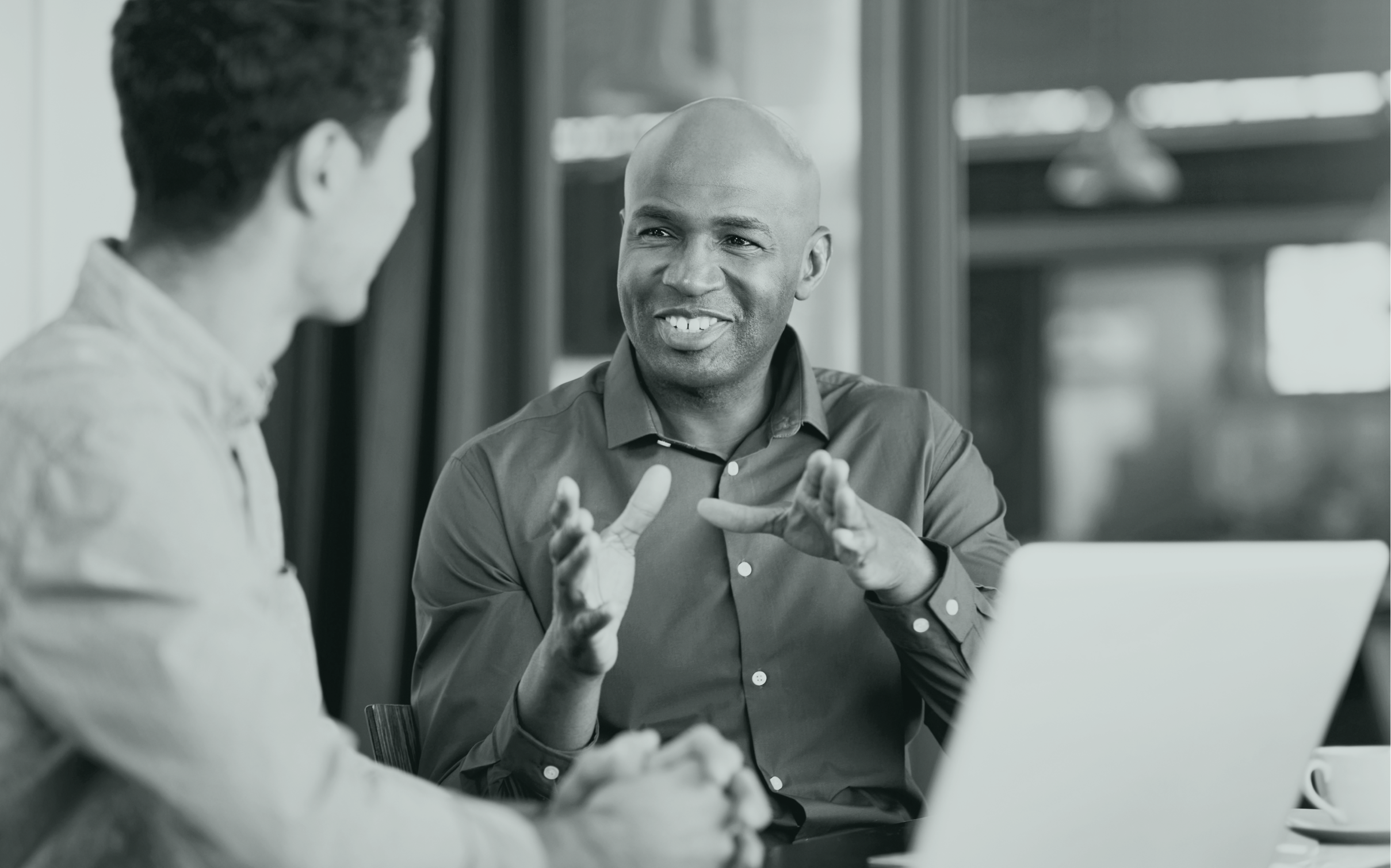 Muvraline-Relation-Clients Deux hommes en pleine conversation dans un bureau