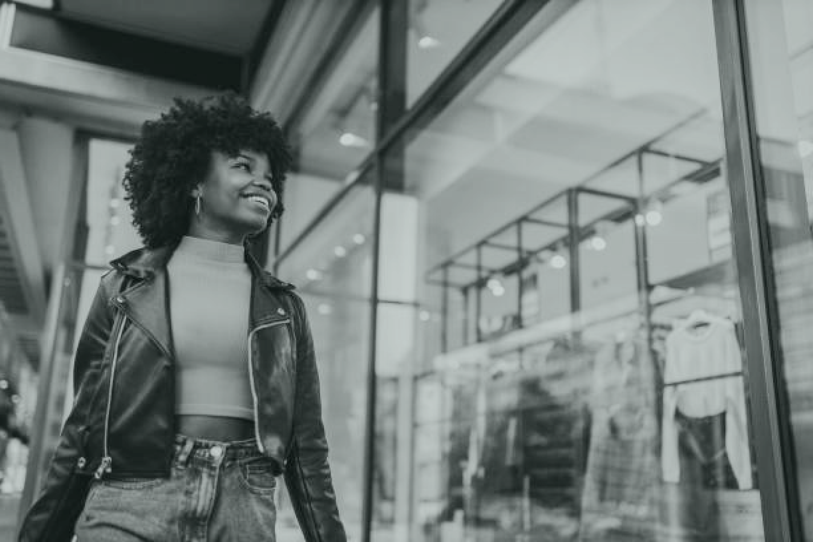 Smiling young woman gazes at a store window in a shopping mall